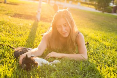 Evcil hayvan ve sahibi kavramı - çim bir kedi ile oynarken güzel kız.