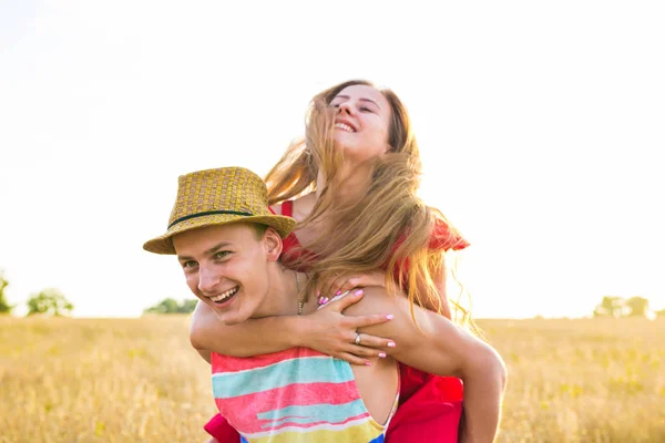 Feliz casal se divertindo ao ar livre no campo. Conceito de Liberdade. Piggyback. . — Fotografia de Stock