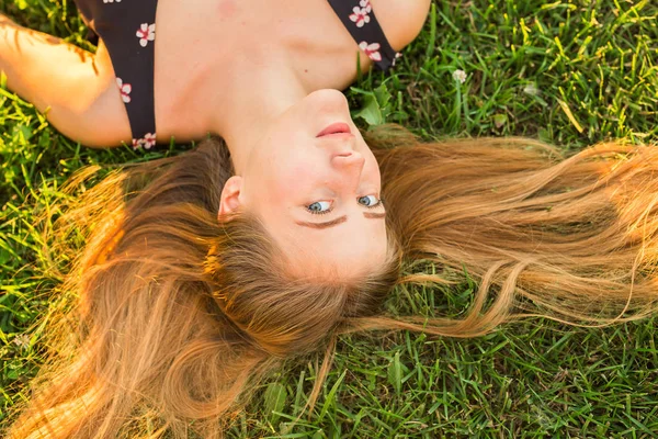 Bovenaanzicht portret van een mooie jonge vrouw ontspannen op een gras-close-up — Stockfoto