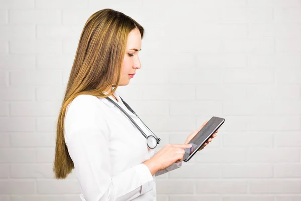Tablet pc에서 노트를 복용 하는 젊은 의사 여자 — 스톡 사진