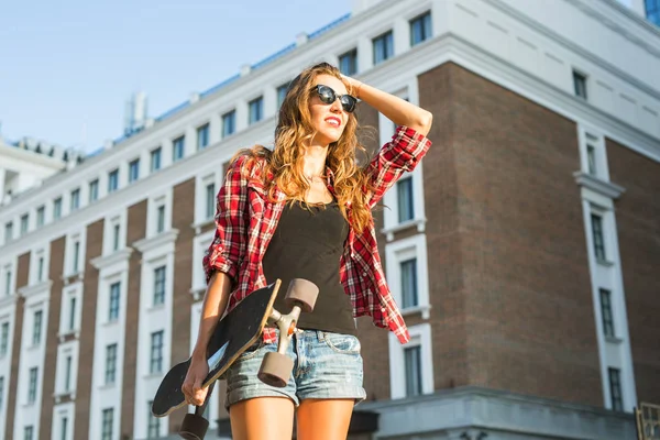 Menina hipster bonita com skate bordo usando óculos de sol — Fotografia de Stock