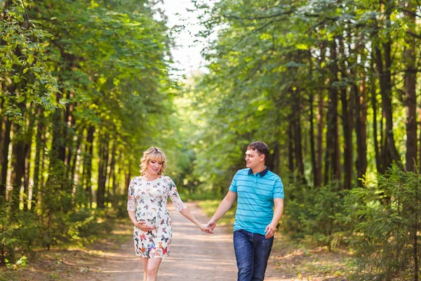 Glad vacker gravid kvinna och hennes man utomhus — Stockfoto