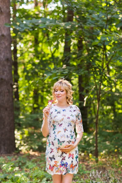Portrait extérieur de jeune femme enceinte tenant une sucette en pleine nature estivale — Photo