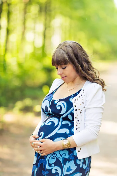 Portrait of pregnant woman relaxing and enjoying life in nature. Stock Photo