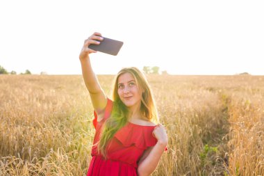 teknoloji, genç kadın alarak selfie yanında smartphone tahıl alanda gülümseyen yaz tatil, tatil ve insanlar kavramı-