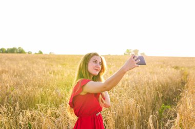 teknoloji, genç kadın alarak selfie yanında smartphone tahıl alanda gülümseyen yaz tatil, tatil ve insanlar kavramı-