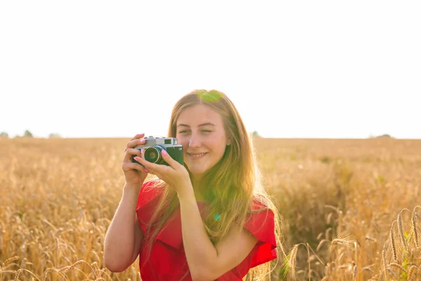 Jonge vrouw in het veld met vintage camera. — Stockfoto