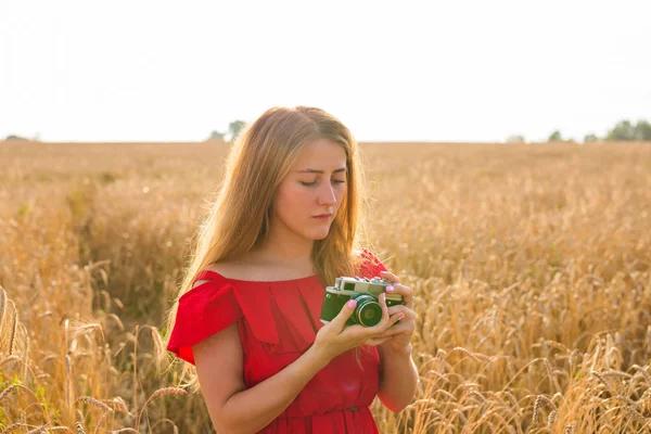 Mujer joven en el campo con cámara vintage . — Foto de Stock