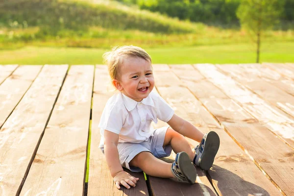 Счастливый смеющийся мальчик, играющий на природе — стоковое фото