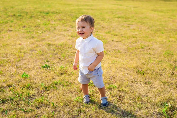 Счастливый смеющийся мальчик, играющий на природе — стоковое фото