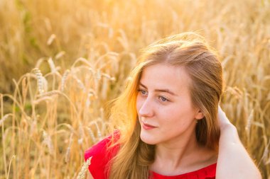 Gün batımında buğday alanında güzel Bayan