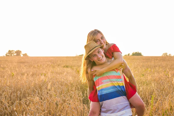 Šťastný pár mají venkovní zábavu na pšeničné pole.. Koncept svobody. Na zádech — Stock fotografie