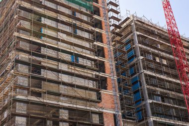 Mavi gökyüzüne karşı inşaat halindeki vinç ve bina