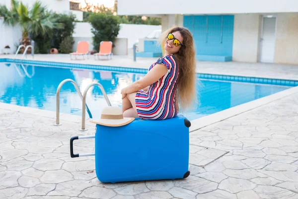 Chica en vacaciones de verano en el fondo de la piscina, vestido a rayas y gafas de sol . — Foto de Stock