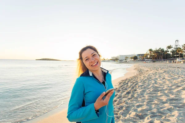 Sport en lifestyle concept - vrouw nadat u hebt uitgevoerd met koptelefoon buitenshuis — Stockfoto