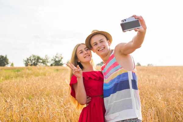 Unga lyckliga paret tar en selfie i fältet — Stockfoto