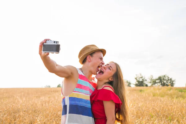 Junges glückliches Paar macht ein Selfie auf dem Feld — Stockfoto