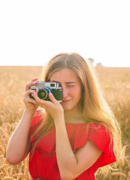 Jonge vrouw in het veld met vintage camera. — Stockfoto