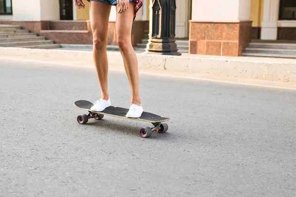 Летние каникулы, экстремальный спорт и люди концепция - крупным планом ноги девушки верхом на современном скейтборде на улице города — стоковое фото