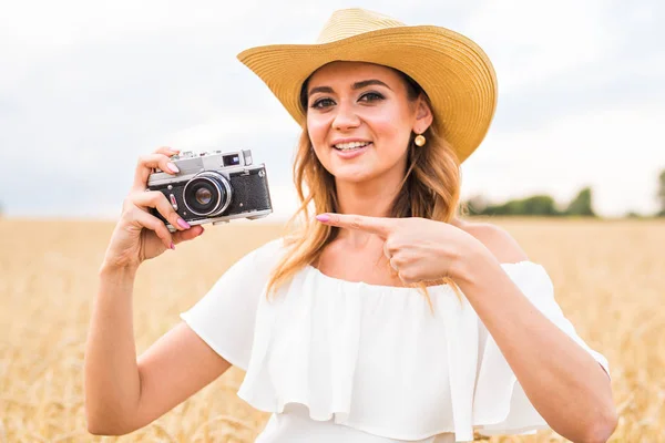 Vrouwelijke fotograaf in het veld met een camera fotograferen — Stockfoto