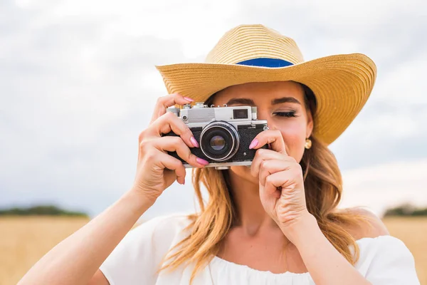 Fotógrafa femenina en el campo con una cámara tomando fotos —  Fotos de Stock