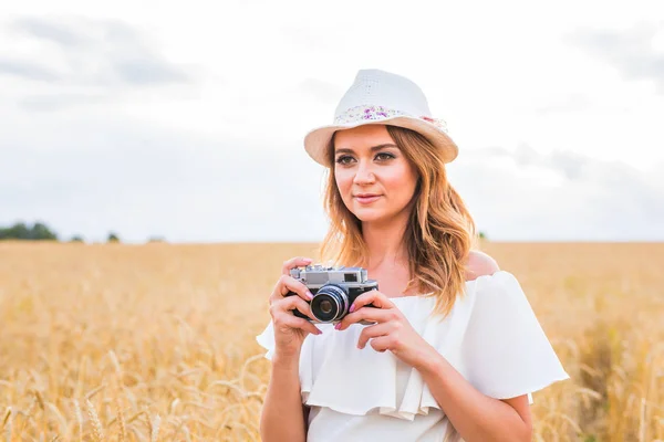Vrouwelijke fotograaf in het veld met een camera fotograferen — Stockfoto
