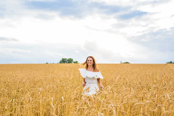 Mulher caminhando no wheat- conceito sobre a natureza, agricultura e pessoas . — Fotografia de Stock