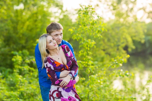 Krásný mladý pár objímat v parku — Stock fotografie