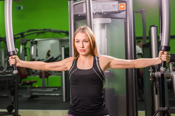 Genç fitness kadın spor salonunda egzersiz egzersiz makinesi ile yürütmek — Stok fotoğraf