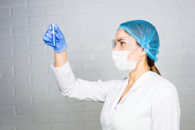 Bilim adamı test tüpüne bakıyor.