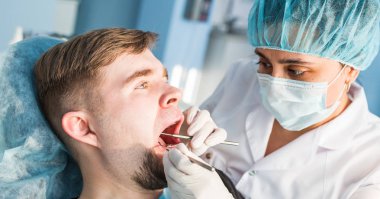 Diş hekimi diş tedavisine hasta yakın çekim yapıyor