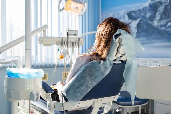患者は歯科用の椅子の上に座って待っている彼女は歯科医。口腔病学の医学、歯科治療、予防、健康概念. — ストック写真