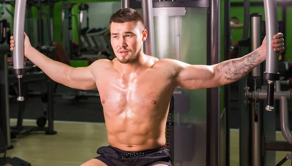 Guapo fitness hombre levantamiento de pesas entrenamiento en el gimnasio —  Fotos de Stock