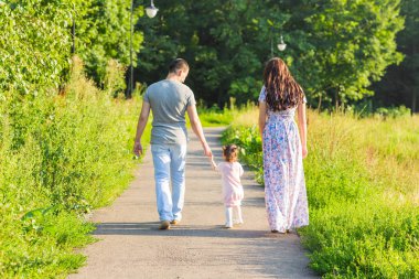 Aile, ebeveynlik ve insanlar kavramı - mutlu anne, baba ve küçük kız yaz parkta yürüyüş