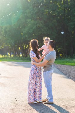 Mutlu aile kavramı - baba, anne ve çocuk eğleniyor ve doğada oynuyor..