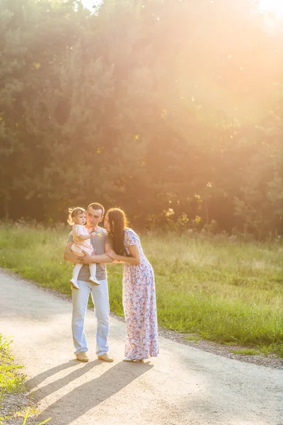 明るい夏の日に田舎道を歩いて混血家族. — ストック写真