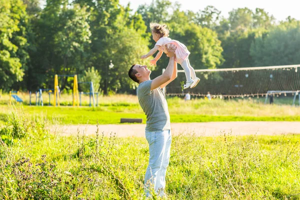 Mixed race father and baby daughter playing in the park — Stock Photo, Image