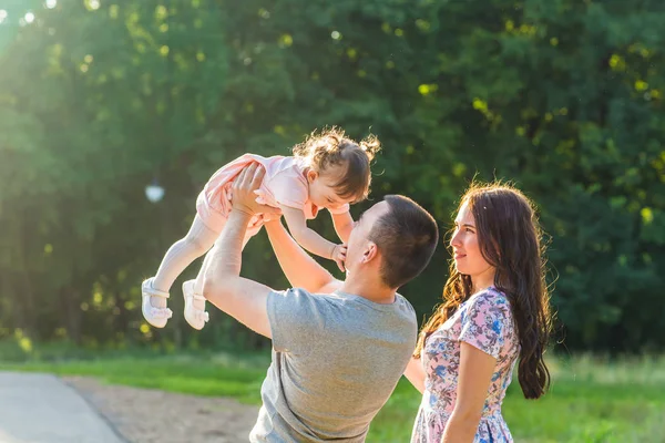 Felice concetto di famiglia - padre, madre e figlia si divertono e giocano nella natura . — Foto Stock