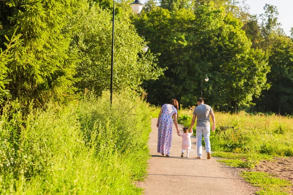 Conceito de família, paternidade e pessoas - mãe feliz, pai e menina caminhando no parque de verão — Fotografia de Stock
