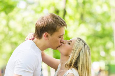 Doğaya aşık romantik mutlu çift. Erkek ve kadın yaz parkta öpüşme.