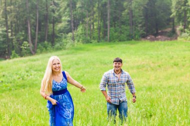 Genç adam ve yeşil çim ile kırsal çayır üzerinde çalışan kadın