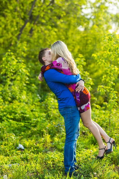 Romántica pareja feliz enamorada de la naturaleza. Hombre y mujer besándose en el parque de verano . — Foto de Stock