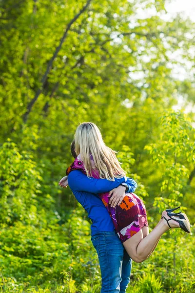 Romantiska lyckliga par i kärlek på naturen. Man och kvinna kyssas och kramas i sommaren park. — Stockfoto