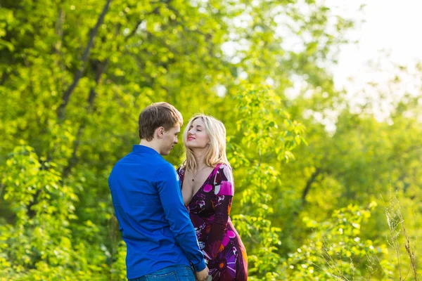 Romántica pareja feliz enamorada de la naturaleza. Hombre y mujer abrazándose en el parque de verano . — Foto de Stock