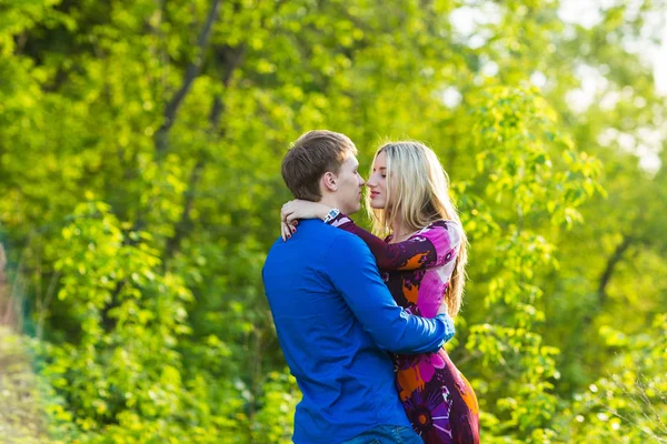 Romantiska lyckliga par i kärlek på naturen. Man och kvinna kysser i sommaren park. — Stockfoto