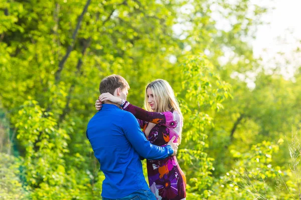 Vacker ung kärlek par kramar i parken — Stockfoto