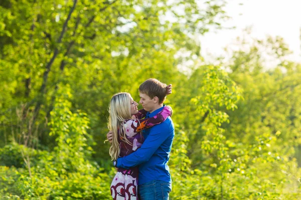 Romántica pareja feliz enamorada de la naturaleza. Hombre y mujer besándose en el parque de verano . —  Fotos de Stock