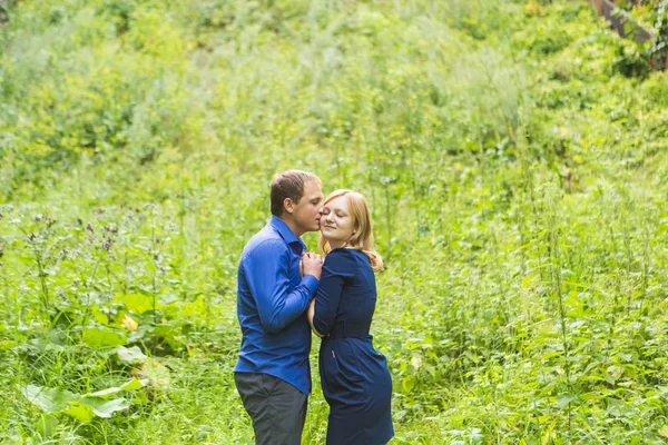 年轻爱夫妇在绿色草地上户外拥抱 — 图库照片
