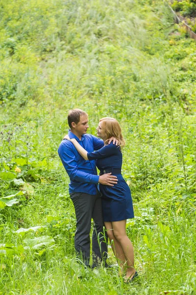 Jovem casal amoroso abraçando ao ar livre na grama verde — Fotografia de Stock