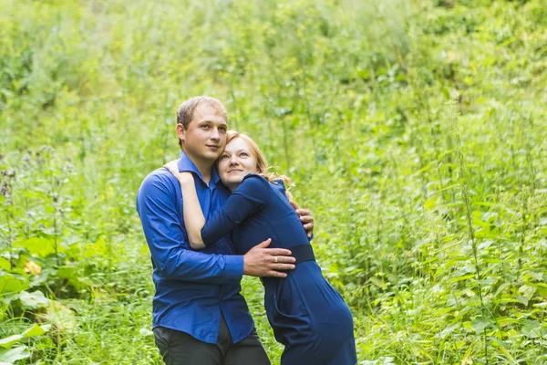 Unga älskande par som kramas utomhus på det gröna gräset — Stockfoto